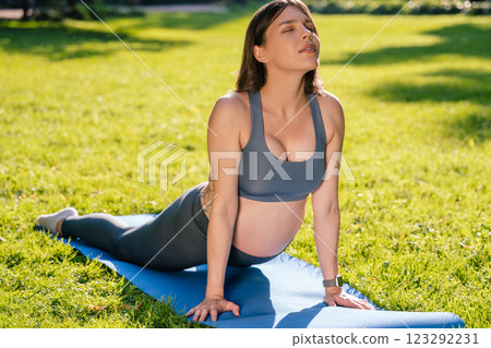 Young caucasian pregnant woman doing morning yoga in the park Young caucasian pregnant woman doing morning yoga in the park 123292231