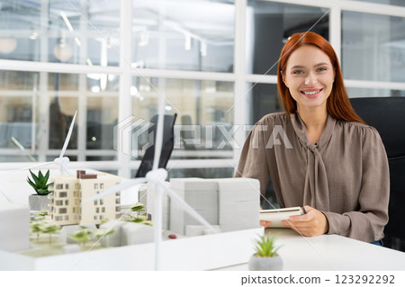 Young female caucasian architect working on a building model in the office 123292292