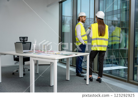 Two engineers working in the office on a new green energy project Two engineers working in the office on a new green energy project 123292925