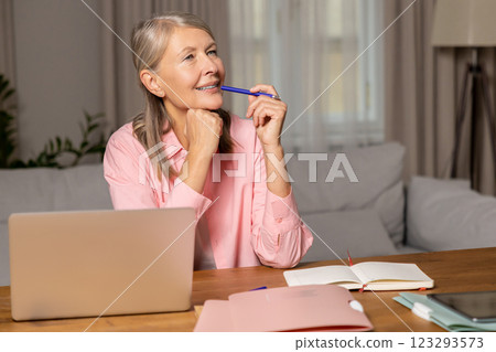 Mid aged caucasian woman sitting at the laptop and feeling inspired 123293573