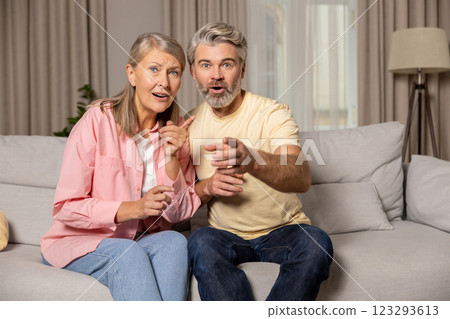 Mature happy couple spending time at home and looking excited Mature happy couple spending time at home and looking excited 123293613