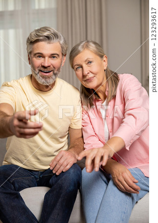 Mature happy couple spending time at home and looking excited Mature happy couple spending time at home and looking excited 123293617
