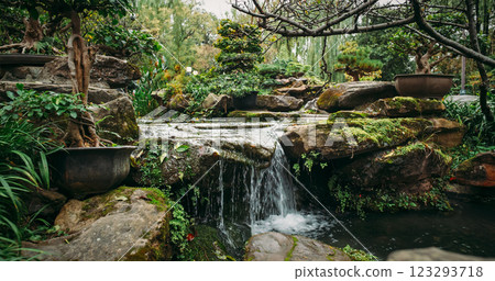 Chengdu, Sichuan, China. Decorative Waterfall In Garden Area Of Wuhou Memorial Temple. Comfortable Environment To Embrace Nature. Zen-like Concept. Silence And Peace. Ornamental Bonsai Tree Chengdu, Sichuan, China. Decorative Waterfall In Garden Area Of Wuhou Memorial Temple. Comfortable Environment To Embrace Nature. Zen-like Concept. Silence And Peace. Ornamental Bonsai Tree 123293718