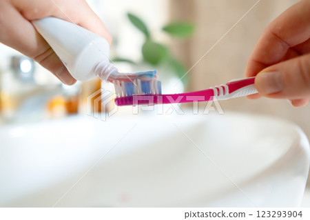 Woman squeezes toothpaste for brushing, using eco-friendly products. Safe toothpaste ensures oral care without harmful ingredients. Woman squeezes toothpaste for brushing, using eco-friendly products. Safe toothpaste ensures oral care without harmful ingredients. 123293904