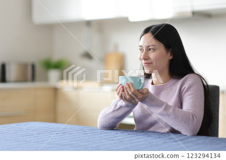 Relaxed asian woman drinking and contemplating Relaxed asian woman drinking and contemplating 123294134