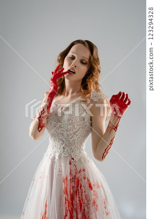 Bride with bloody hands elegantly poses in exquisite lingerie and a katana Bride with bloody hands elegantly poses in exquisite lingerie and a katana 123294328
