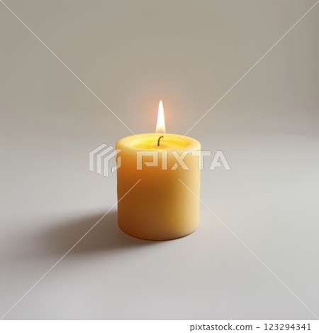 Lit Yellow Candle in Peaceful Setting Focused on Calming Glow 123294341