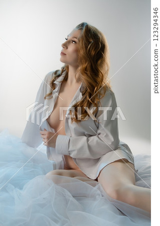 Lingerie-clad woman poses gracefully in a soft, intimate setting Lingerie-clad woman poses gracefully in a soft, intimate setting 123294346