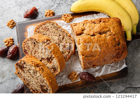 Gluten free and lactose free Date banana walnuts bread loaf close up on wooden board. Horizontal top view 123294417