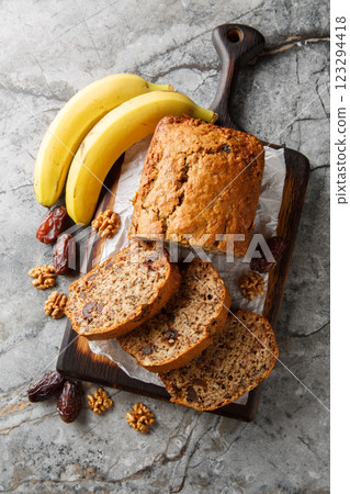 Date banana nuts diet bread close-up on wooden board. Vertical top view Date banana nuts diet bread close-up on wooden board. Vertical top view 123294418