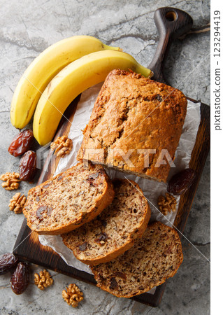 Homemade Date banana walnuts bread loaf close-up on wooden board. Vertical top view 123294419