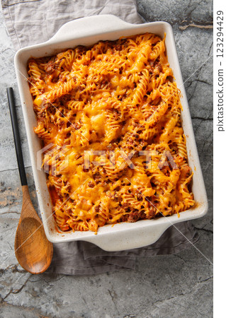 Sloppy Joe Casserole is loaded with juicy ground beef and pasta smothered in a cheesy sauce closeup in the baking dish. Vertical top view Sloppy Joe Casserole is loaded with juicy ground beef and pasta smothered in a cheesy sauce closeup in the baking dish. Vertical top view 123294429