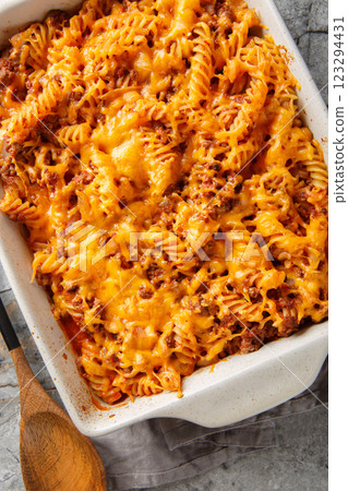 Delicious sloppy joe casserole with meat, pasta, vegetables and sauce and lots of cheese close-up in baking dish on table. Vertical top view Delicious sloppy joe casserole with meat, pasta, vegetables and sauce and lots of cheese close-up in baking dish on table. Vertical top view 123294431