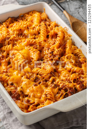 Sloppy Joe Casserole made with pasta, a saucy ground beef mixture and shredded cheese closeup in the baking dish. Vertical 123294435