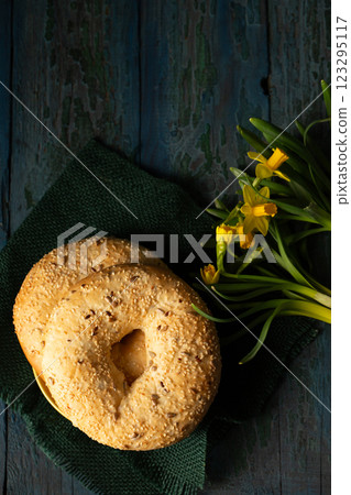Still life in rustic style bagels sprinkled with seeds with yellow daffodils 123295117