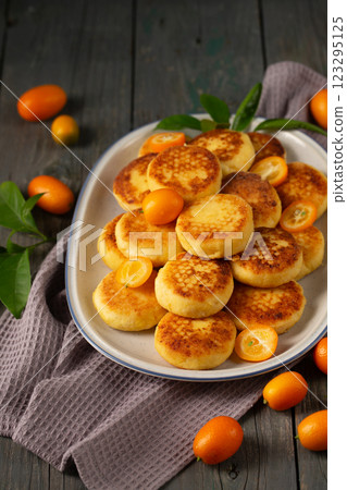 Delicious cheesecakes with kumquats in a plate Delicious cheesecakes with kumquats in a plate 123295125