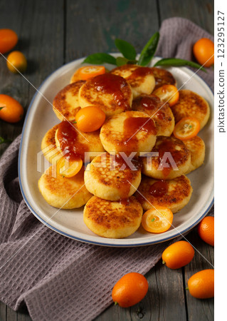 Delicious cheesecakes with delicious kumquats and citrus jam in a large oval plate 123295127