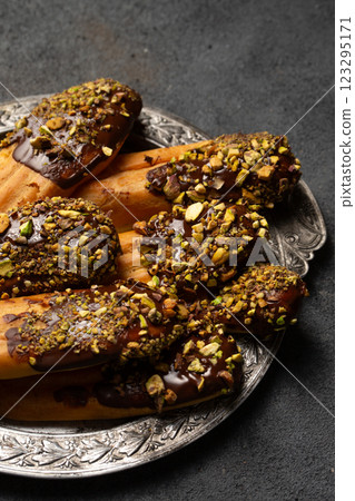 Chocolate and pistachio custard cookies on a vintage metal plate, close-up 123295171