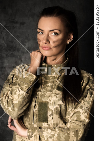 Beautiful military woman in Ukrainian military uniform with camouflage makeup on her face 123295257