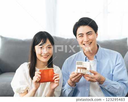 一對夫婦拿著樣品屋和一個錢包 - 住房金融 123295483