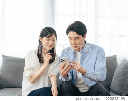 一對夫婦在客廳看智慧型手機 一對夫婦在客廳看智慧型手機 123295493