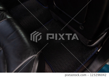 Clean car floor mats of black rubber under rear passenger seat in the workshop for the detailing vehicle dry cleaning. Auto service industry. Interior of sedan. 123296042