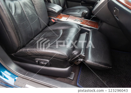 Close-up on front passenger seat with black leather trim and ottoman for legs rest upholstery in the interior of an Japanese car in gray after dry cleaning. Auto service industry. 123296043
