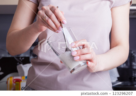 Making cupcakes at home. A woman prepares Easter cakes in the kitchen by whipping soda in a glass. Making cupcakes at home. A woman prepares Easter cakes in the kitchen by whipping soda in a glass. 123296207