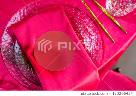 Setting a festive table with a red tablecloth and napkins with a name card. Setting a festive table with a red tablecloth and napkins with a name card. 123296434