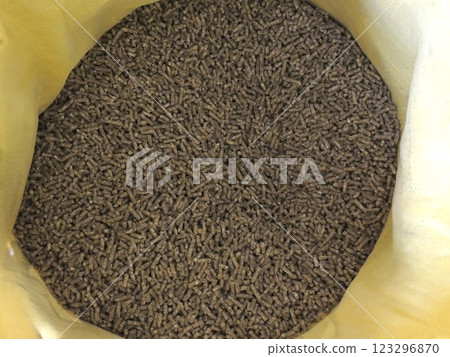 open yellow bag of mixed feed for poultry, balanced granules of plant-protein feed in bright synthetic packaging, pellets for feeding farm birds 123296870