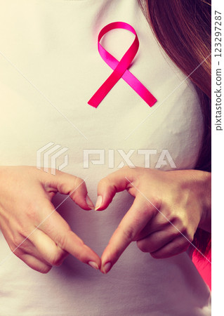 Breast cancer. Female hands make heart on pink ribbon Breast cancer. Female hands make heart on pink ribbon 123297287