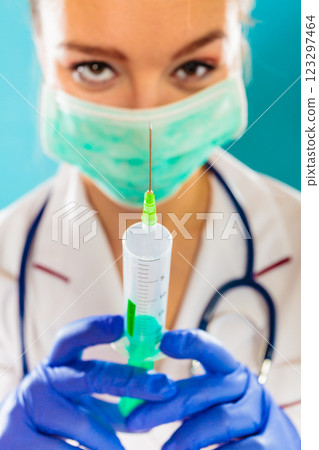 doctor in mask holding syringe with injection 123297464
