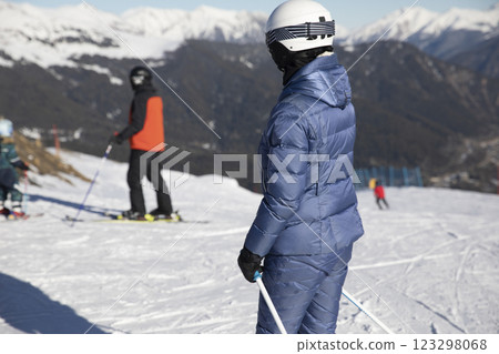 Skiers and snowboarders ride on a mountain ski track with snow Skiers and snowboarders ride on a mountain ski track with snow 123298068