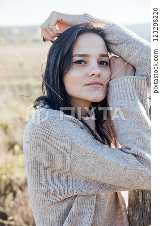 Beautiful brunette woman in sweater in rural area 123298220