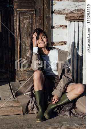 Beautiful fashionable brunette woman in gray coat on wooden stairs 123298229