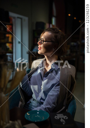 woman 40 years old reading a book in a restaurant woman 40 years old reading a book in a restaurant 123298259