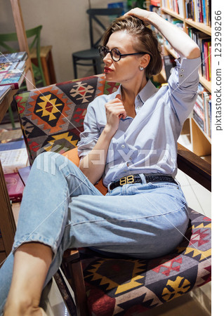 Woman in glasses sitting in chair 123298266