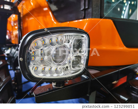 Bright headlight on a modern agricultural tractor showcased at a farming equipment exhibition Bright headlight on a modern agricultural tractor showcased at a farming equipment exhibition 123299851