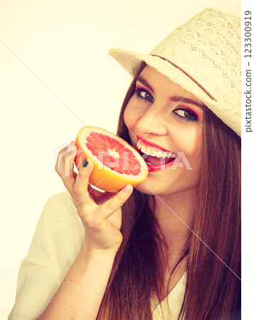 Woman holding half of grapefruit citrus fruit in hand Woman holding half of grapefruit citrus fruit in hand 123300919