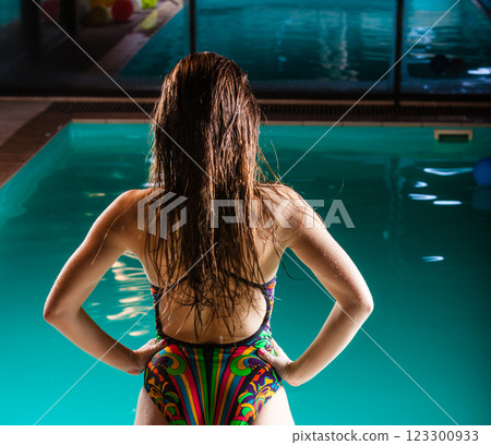 Woman back in swimsuit on pool edge. 123300933