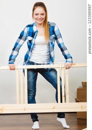 Woman assembling wooden furniture. DIY. 123300997