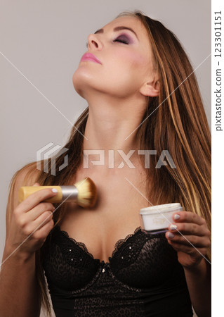 Woman in lingerie applying loose powder with brush 123301151