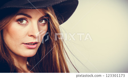 pretty girl with brown hair and black hat. 123301173