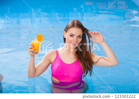 Girl with cocktail drink relaxing at swimming pool Girl with cocktail drink relaxing at swimming pool 123301222