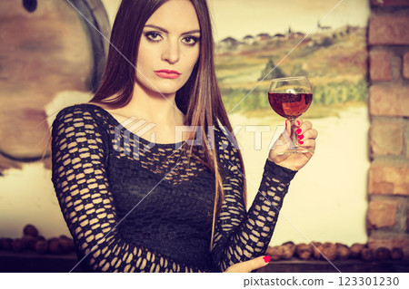 Woman tasting wine in rural cottage interior 123301230
