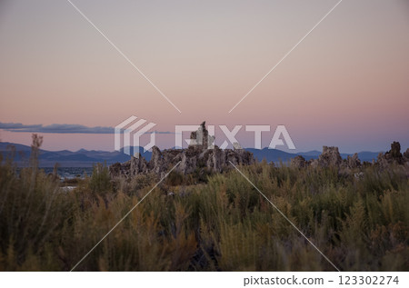 Tufa formations at Mono Lake with mountains in the background during sunset. Concept of unique geological landscapes, nature preservation, and remote wilderness. 123302274