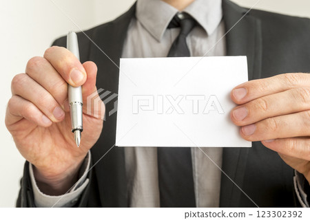 Businessman Holding Pen and Empty White Paper 123302392