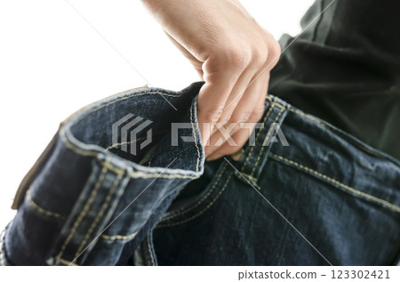 Detail of woman skinny waist in too large old jeans Detail of woman skinny waist in too large old jeans 123302421