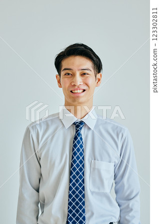 Young man in a dress shirt looking at camera on white background Young man in a dress shirt looking at camera on white background 123302811