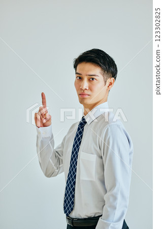 A young man in a dress shirt pointing up A young man in a dress shirt pointing up 123302825
